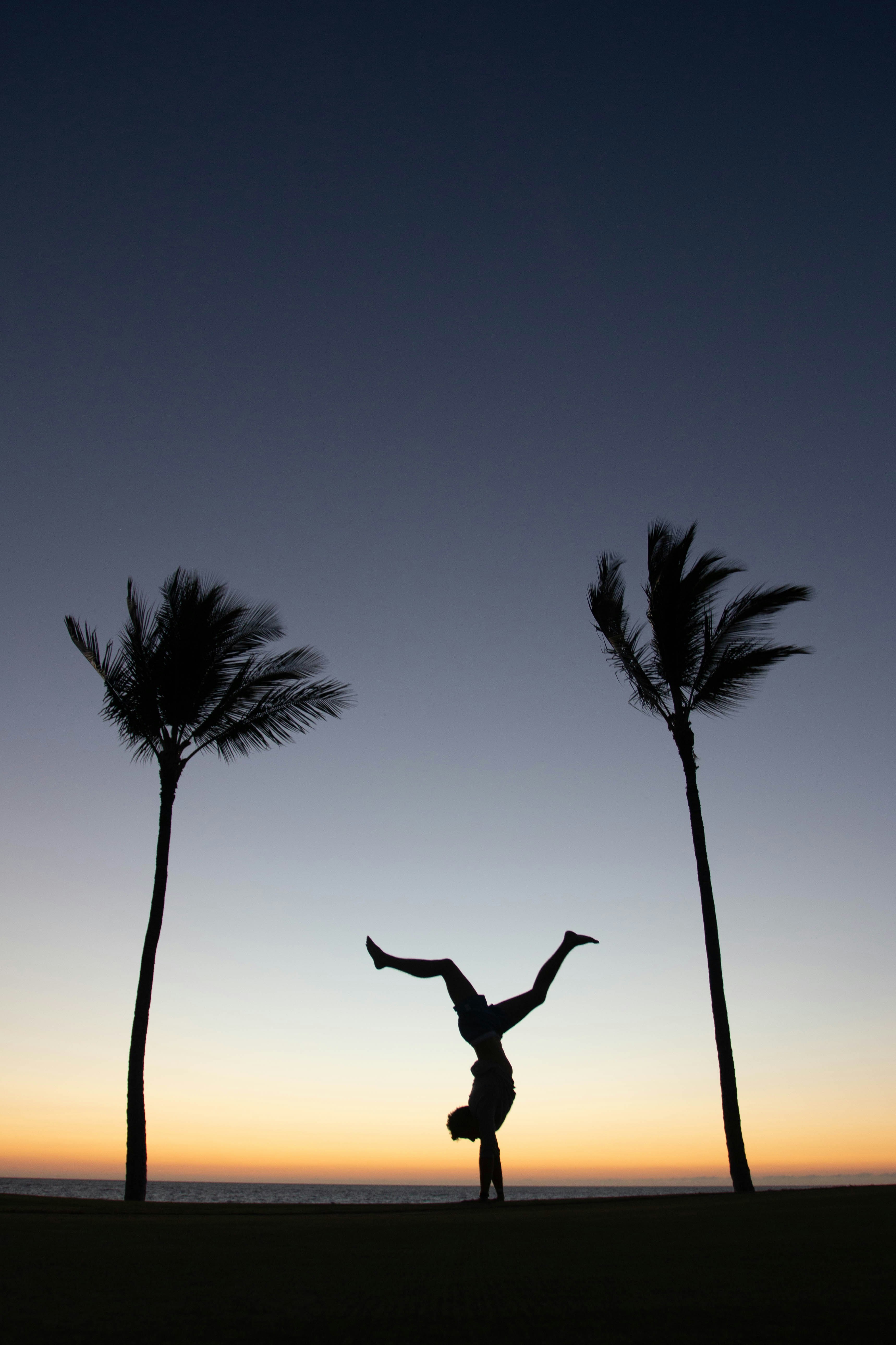 man doing exercise during sunset